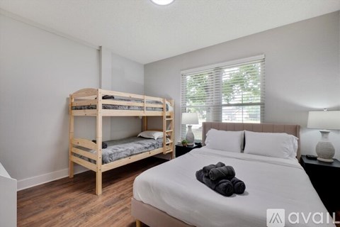 A bedroom with a bunk bed and a single bed with towels on top.