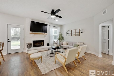 A living room with a fireplace and a television mounted above it.