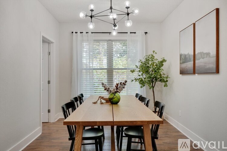 A dining room with a wooden table and chairs.