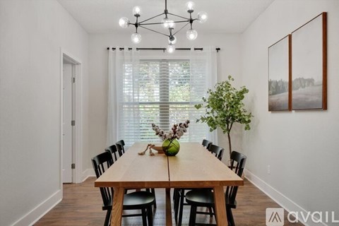 A dining room with a wooden table and chairs.