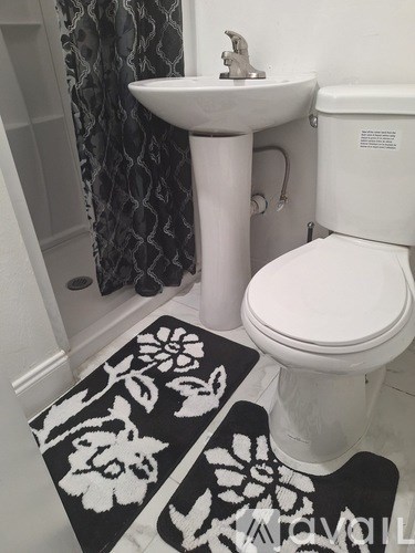 A white toilet sits next to a sink in a bathroom.