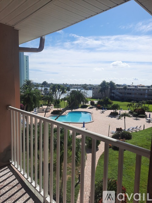 A balcony overlooks a pool and a view of the city.