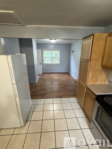 A kitchen with white appliances and wooden cabinets.