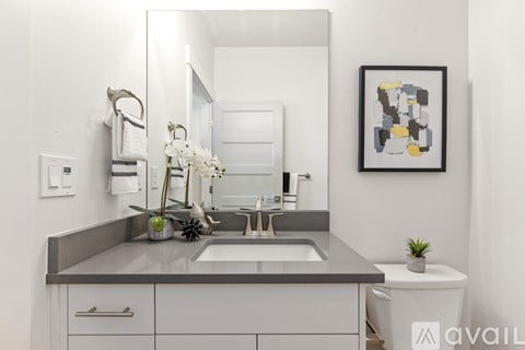 A bathroom with a sink, mirror, and toilet.
