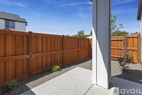A wooden fence with a white pillar in the foreground.