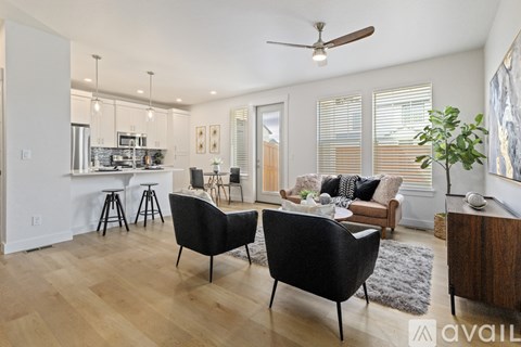 A living room with a black chair and a wooden floor.