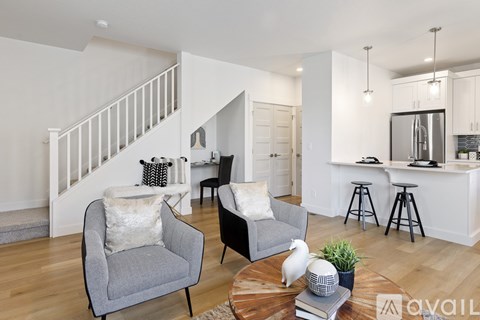 A living room with a grey armchair and a black chair with a small table between them.