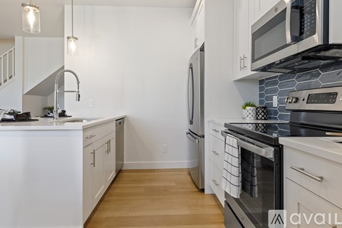 A kitchen with white cabinets and a black stove top.