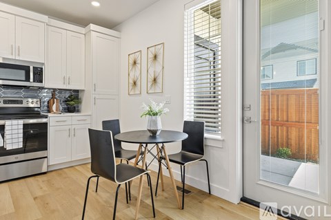 A kitchen with a table and chairs in front of a window.