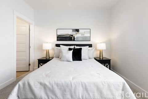 A bedroom with a large bed and a framed picture above it.