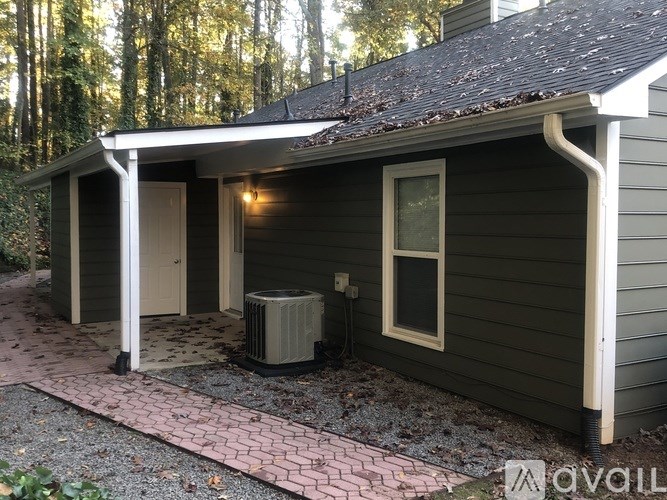 A small house with a covered patio and a brick walkway.