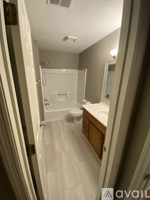A bathroom with a toilet, sink, and shower.