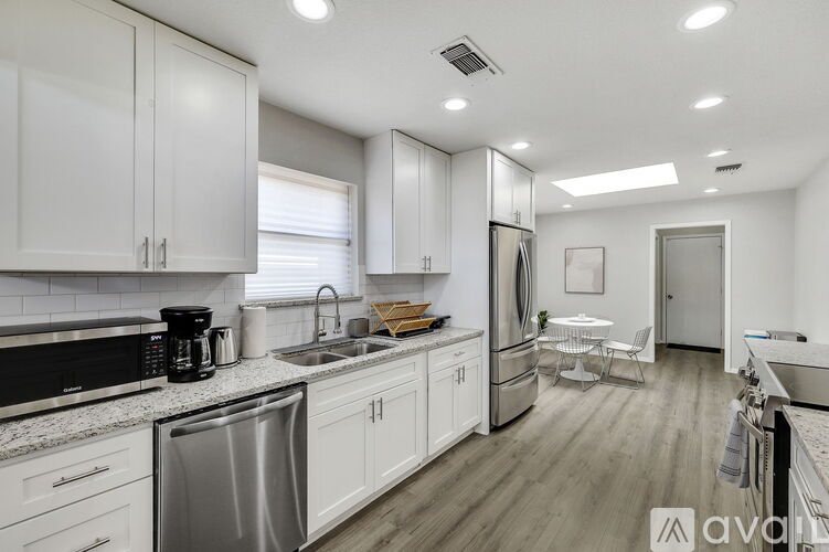 A modern kitchen with white cabinets and stainless steel appliances.