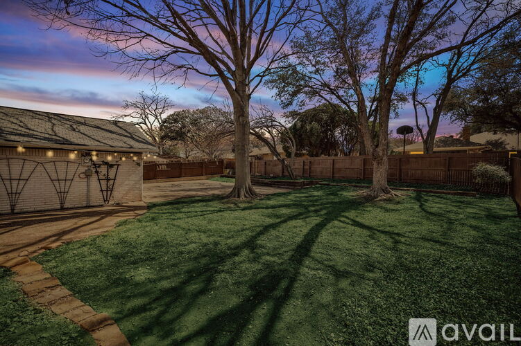 A backyard with a lawn and trees.
