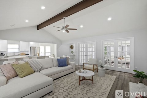 A living room with a white couch and a ceiling fan.