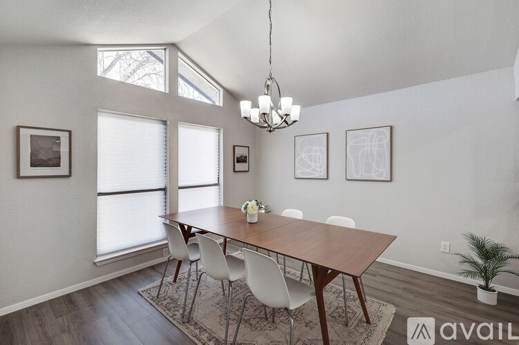 A dining room with a wooden table and chairs.