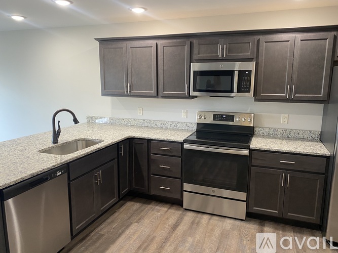 A kitchen with dark brown cabinets and stainless steel appliances.
