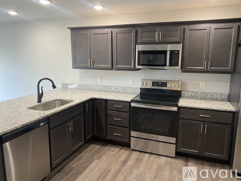 A kitchen with dark brown cabinets and stainless steel appliances.