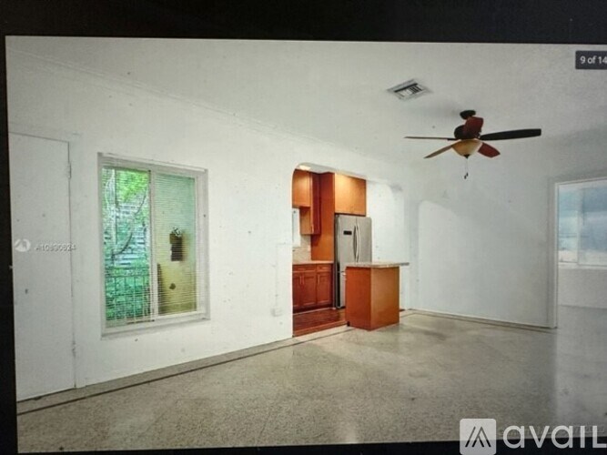 A room with a ceiling fan and a door leading to another room.