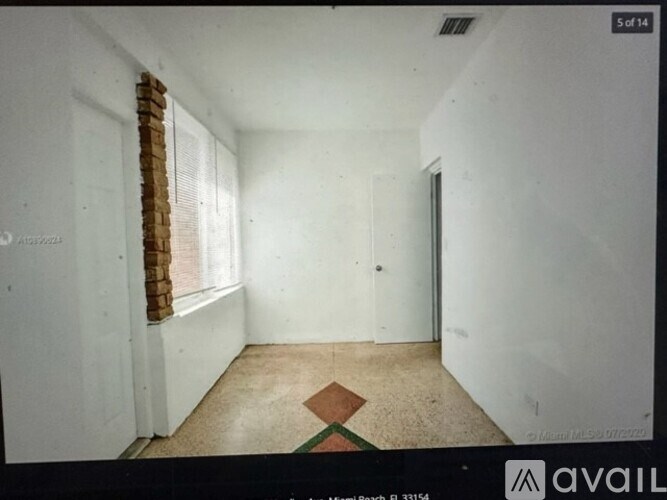 A room with a window and a door is available for rent.