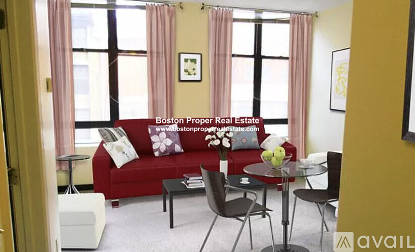A living room with a red couch and a glass table.