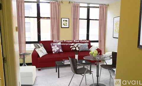 A living room with a red couch and a glass table.