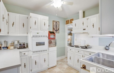 A kitchen with white cabinets and a white oven.