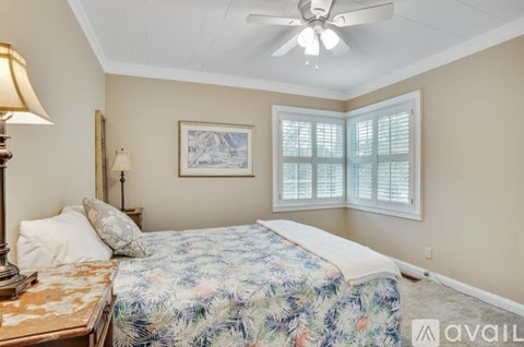 A bedroom with a bed, a lamp, and a painting on the wall.