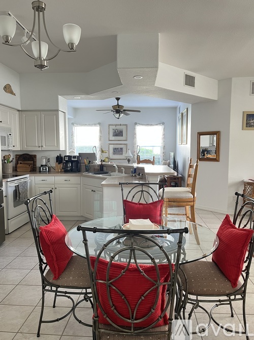 A kitchen with a table and chairs.