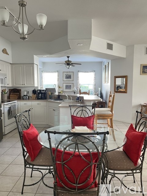 A kitchen with a table and chairs.