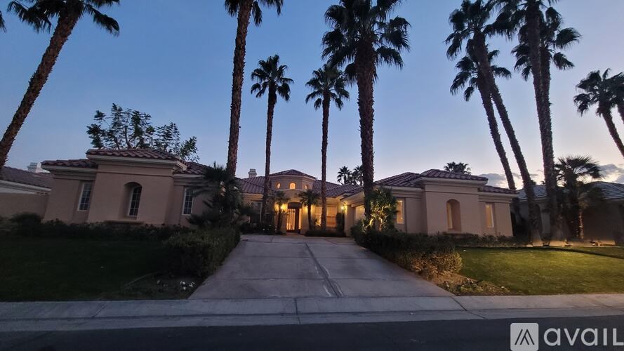 A house with palm trees in front of it is available for sale.