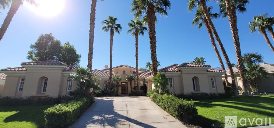 A sunny day in a gated community with palm trees and houses.