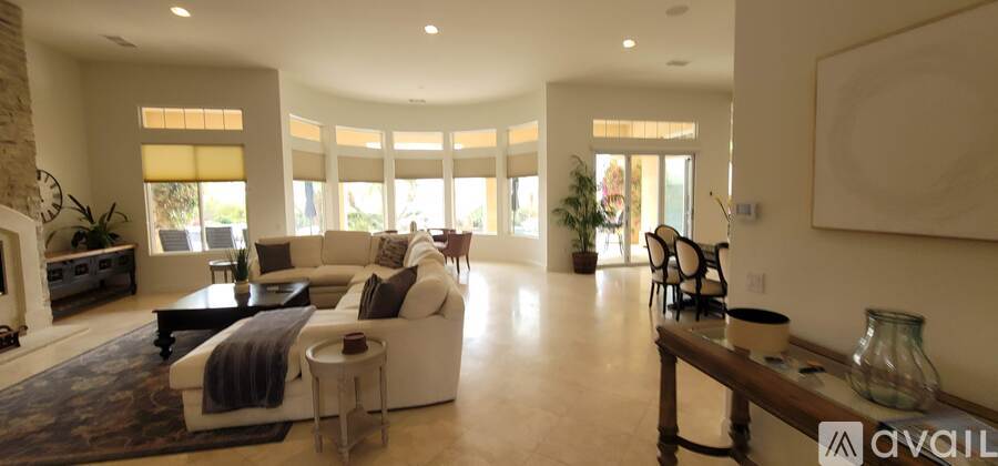 A spacious living room with a large couch and a long wooden bench.