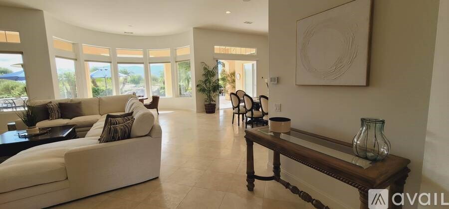 A spacious living room with a large couch and a long wooden bench.