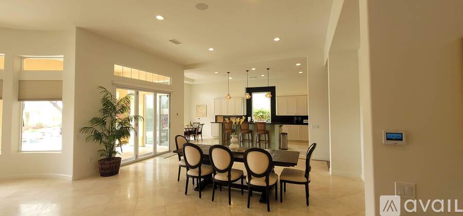 A dining room with a large table and chairs.