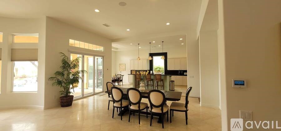 A dining room with a large table and chairs.