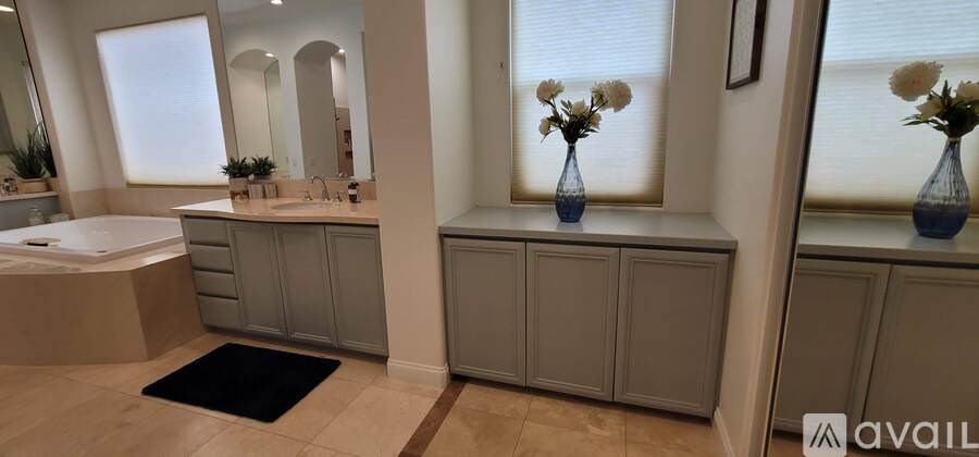 A pool table is in the middle of a room with a television mounted on the wall.