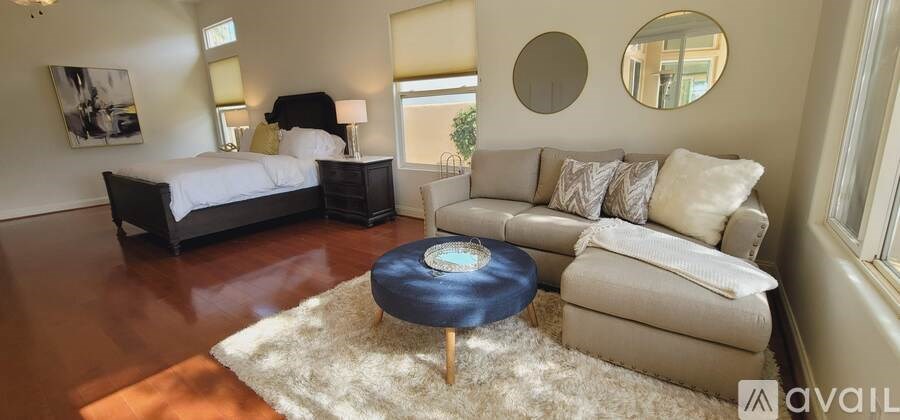 A bedroom with a large bed and a couch.