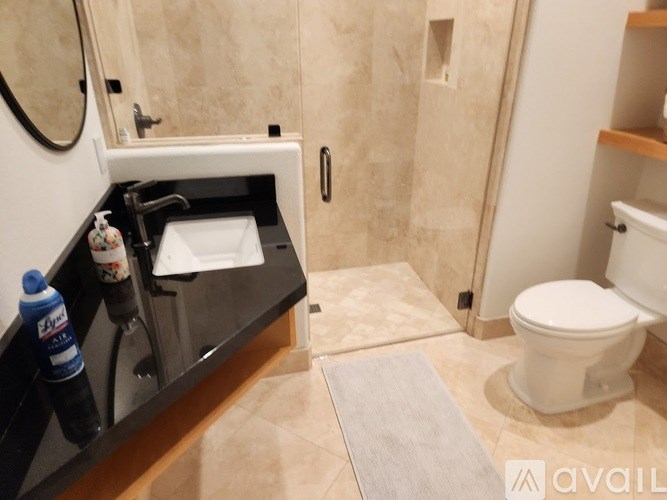 A bathroom with a toilet, sink, and mirror.