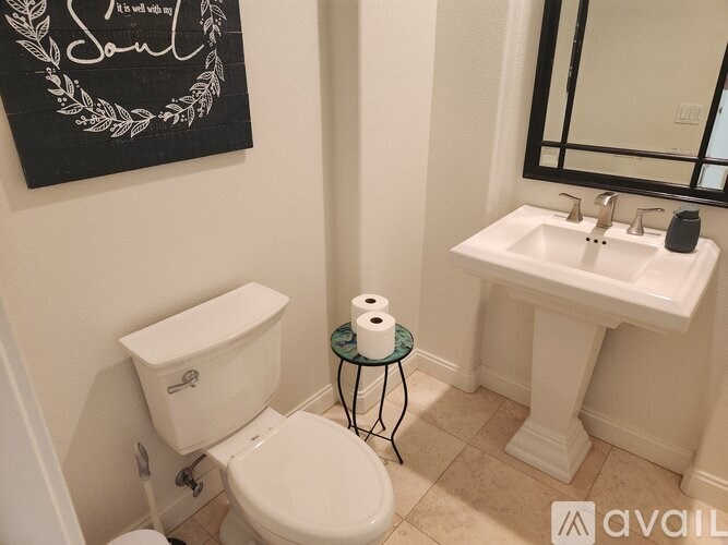 A bathroom with a toilet, a sink, and a mirror.