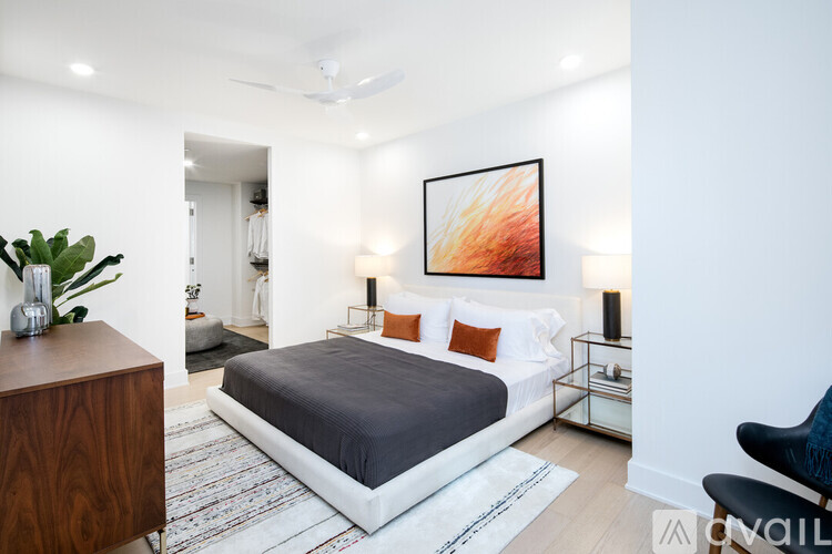 A bedroom with a large bed and a painting on the wall.