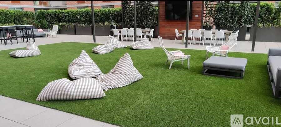 A patio with white chairs and striped cushions.