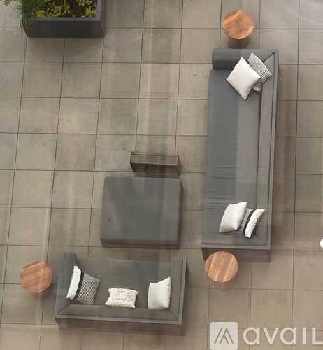 A modern outdoor furniture set is displayed on a tiled floor.