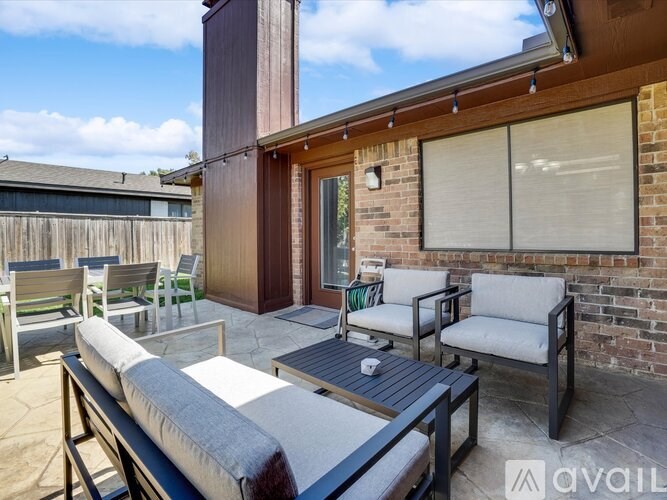 A patio with a couch, chairs, and a table is available for rent.