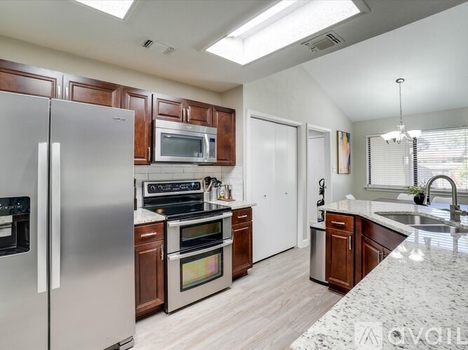 A modern kitchen with a refrigerator, oven, microwave, and sink.