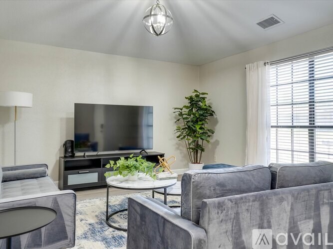 A living room with grey couches and a flat screen TV.