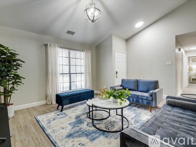 A living room with a blue sofa and a round coffee table.