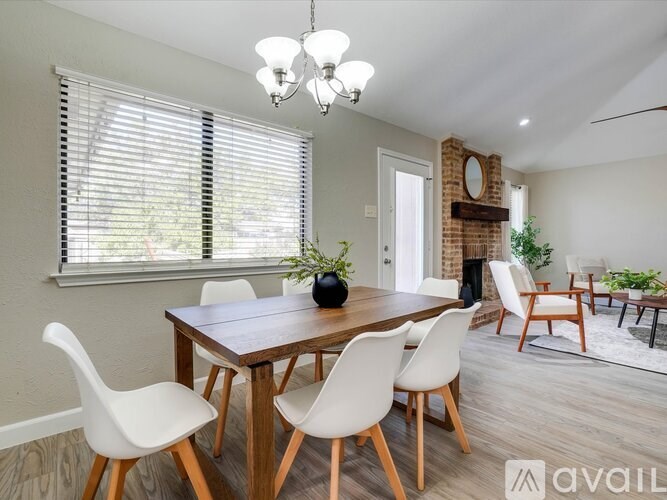 A dining room with a wooden table and white chairs.