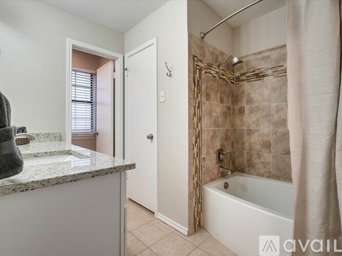 A bathroom with a tub, sink, and shower.