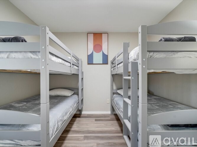 A room with bunk beds and a painting on the wall.